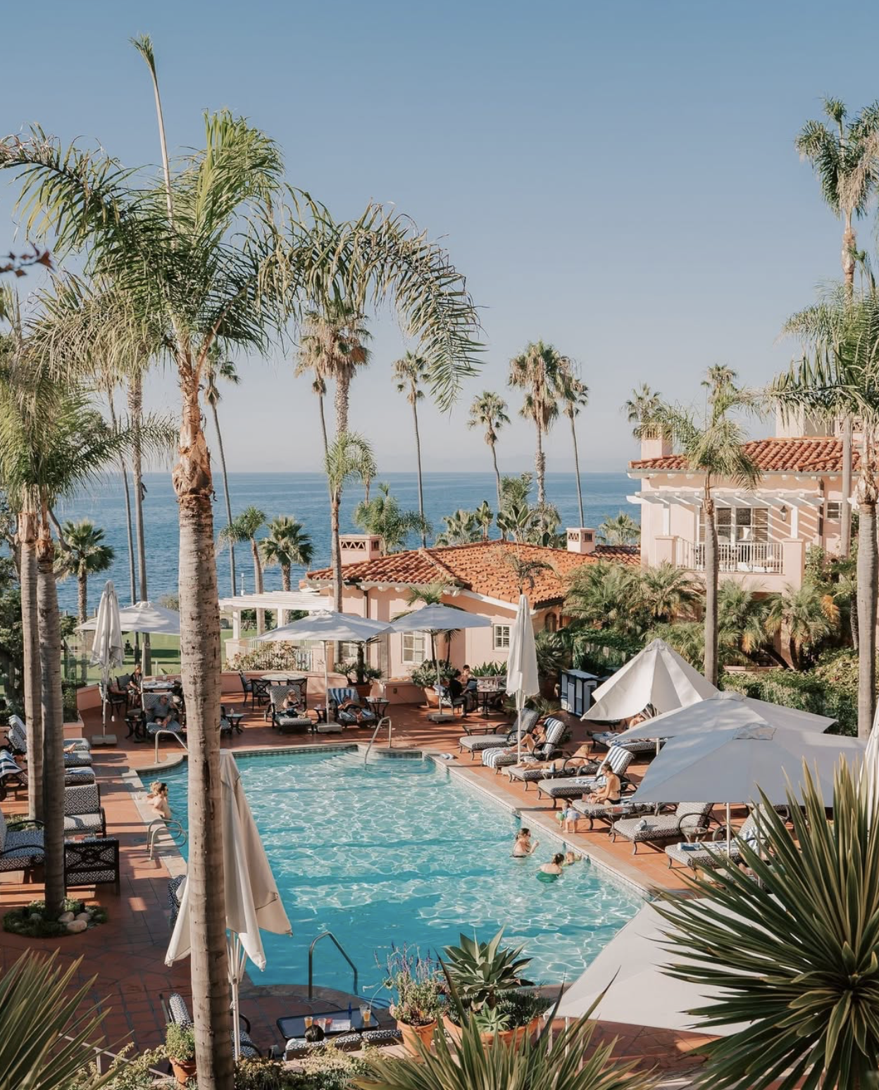 La Valencia Hotel features soft pink architecture, ocean views and tropical landscaping